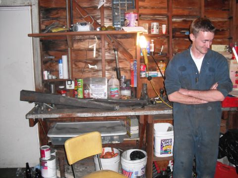 1991 Ford Bronco - A man stands in a workshop filled with tools and supplies.