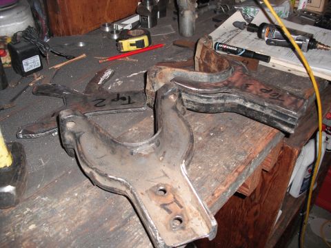 1991 Ford Bronco - Custom suspension components, marked 'Top 2' and 'Top 3', sit on a cluttered workbench alongside tools.