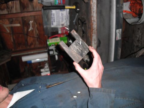 1991 Ford Bronco - A person holds a fabricated metal part in a workshop setting.