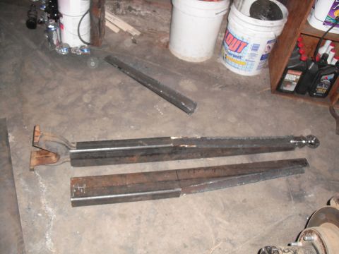 1991 Ford Bronco - Custom fabricated radius arms are laid out on a concrete floor, likely for a vehicle modification project.