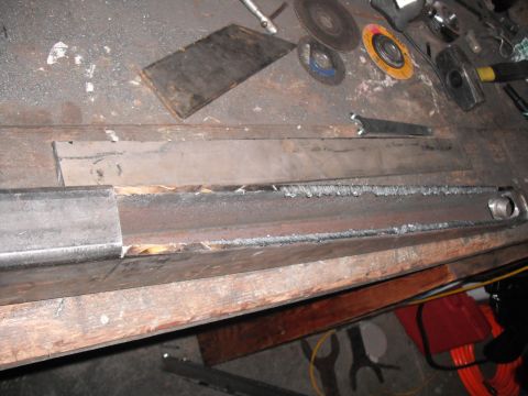 1991 Ford Bronco - Metal parts are being welded together on a workbench with various tools visible.