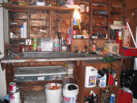 1991 Ford Bronco - A cluttered workbench in a garage setting, filled with various tools and supplies.