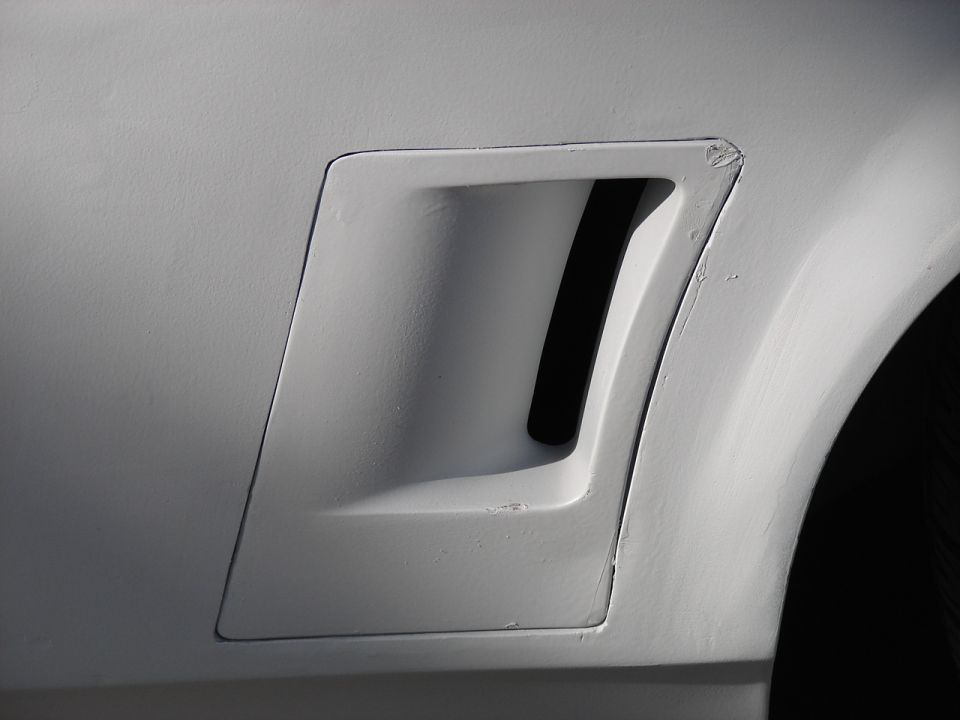 White car fender vent with black interior, close-up side view