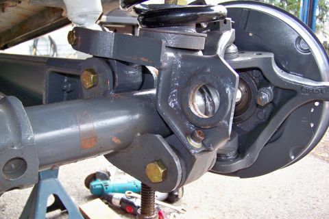 1989 Ford Bronco - Vehicle axle and suspension components are shown on jack stands, with tools visible in the background.