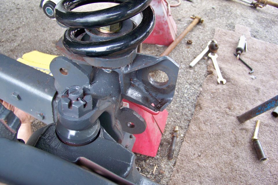 close-up of a vehicle's front suspension assembly with a coil spring and shock mount