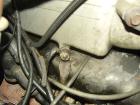 2007 Ford Mustang - Close-up view of engine parts, including wiring and hoses, with signs of wear and oil.