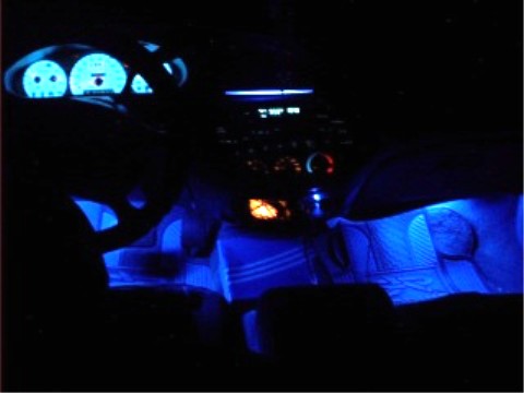 1997 Ford Taurus - The interior of a car is lit with blue ambient lighting, highlighting the dashboard and seats.