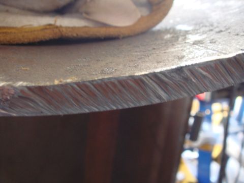 1992 Ford Bronco - A close-up view of a cut metal disc edge, with a gloved hand visible at the top.