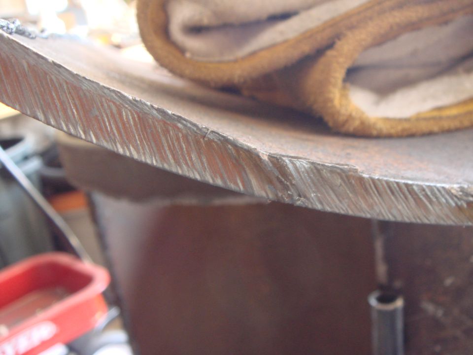 Close-up of a metal edge with visible tool marks and a folded piece of fabric