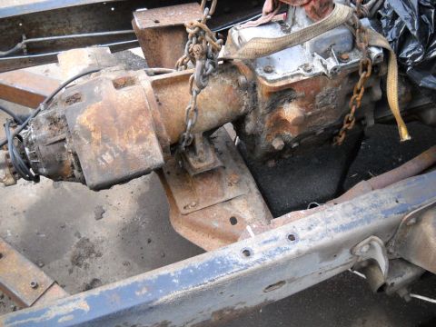 1954 Ford F-100 - Close-up view of heavily rusted transmission and chassis components being worked on.