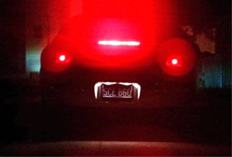 1997 Ford Taurus - The rear of a car is illuminated by its bright red taillights, with the license plate SCE 860 visible.