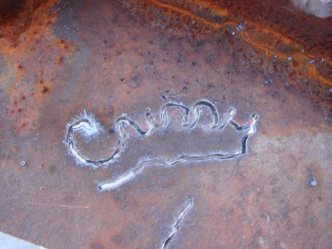 1992 Ford Bronco - A cutout crown emblem is visible on heavily rusted metal, suggesting a custom modification or part.