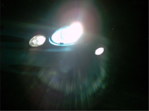1997 Ford Taurus - Headlights and fog lights illuminated at night, with Supermotors.net logo in the corner.