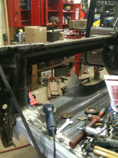 1993 Ford Bronco - Tools and a grinder are on the floor of a vehicle interior being repaired.