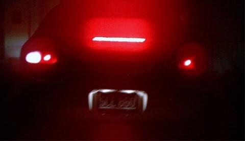 1997 Ford Taurus - The rear of a car is illuminated by its red brake lights and a horizontal light bar.