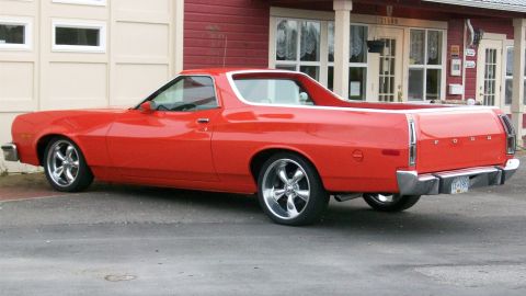 1973 Ford Ranchero - This red 1973 Ford Ranchero features custom wheels and a chrome bumper, viewed from the rear three-quarter angle.