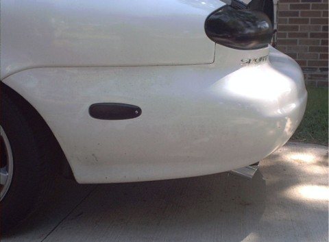 1997 Ford Taurus - Rear view of a white car showing a side marker light and taillight assembly.