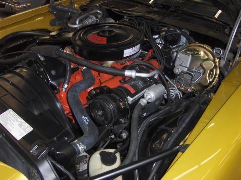 1979 Chevrolet Camaro - The engine bay of a yellow 1979 Chevrolet Camaro is shown, detailing the V8 engine and its components.