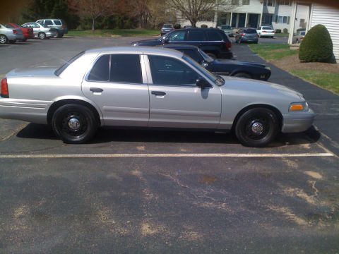 2009 Ford Crown Victoria - Side profile of a silver 2009 Ford Crown Victoria sedan parked in a lot.
