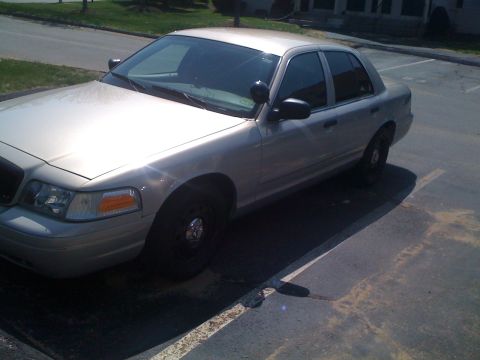 2009 Ford Crown Victoria - A silver 2009 Ford Crown Victoria is parked in a lot on a sunny day.