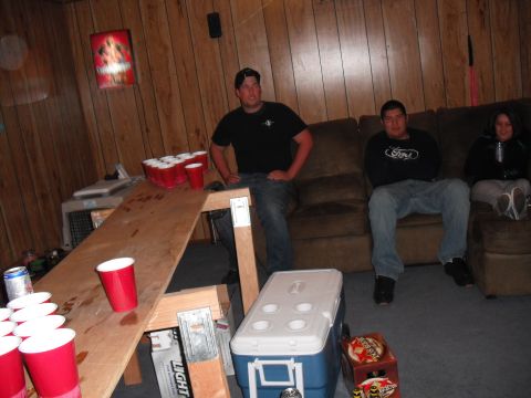 1991 Ford Bronco - A group of people are gathered in a room, with a beer pong table set up and red cups scattered around.