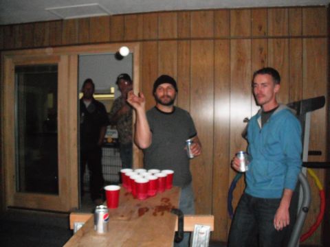 1991 Ford Bronco - A group of men are gathered indoors, playing a game of beer pong.