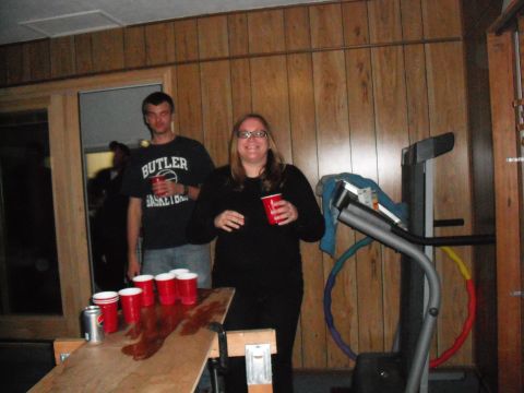 1991 Ford Bronco - A man and woman are in a room with wood paneling, standing near a beer pong setup.