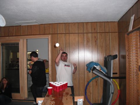 1991 Ford Bronco - A group of people are gathered indoors, with some playing a game of beer pong.