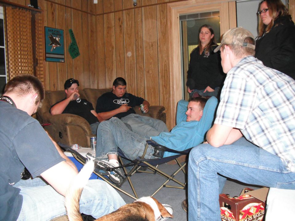 Group of people relaxing in a room with wood-paneled walls