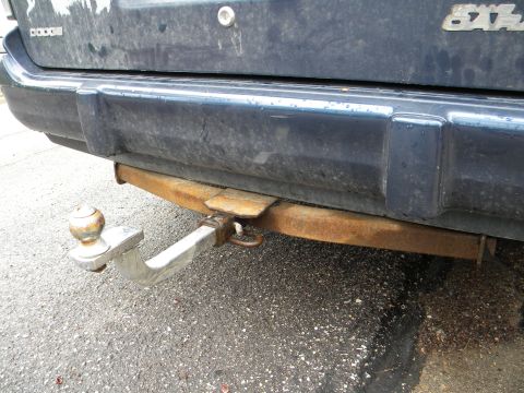 1993 Dodge Grand Caravan - The rear of a minivan shows a trailer hitch and the 'DODGE' nameplate.