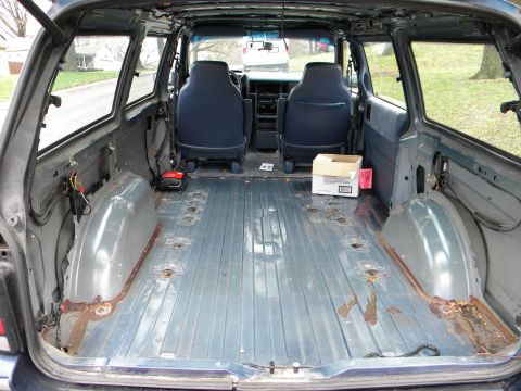 1993 Dodge Grand Caravan - The interior of a 1993 Dodge Grand Caravan, stripped down to its bare metal floor, reveals signs of wear and tear.