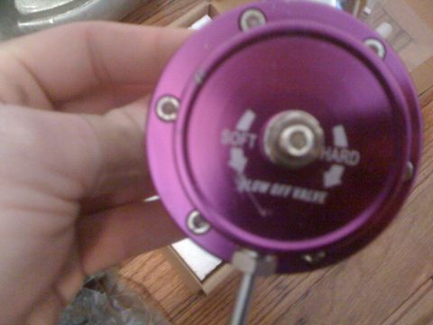 1995 Ford Bronco - A person holds a purple blow off valve, showing adjustment settings for 'soft' and 'hard'.