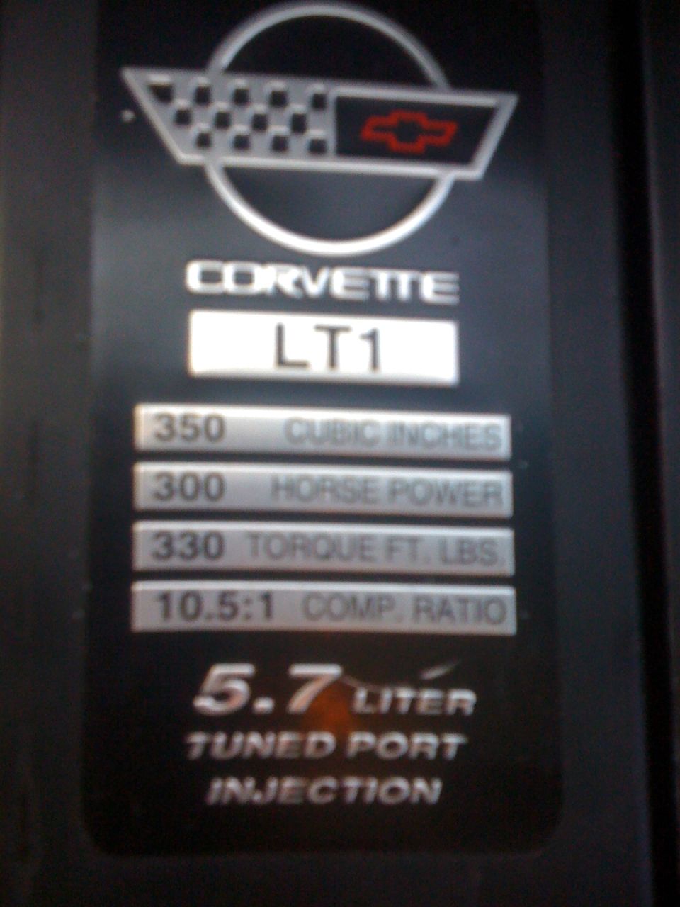Corvette LT1 engine data plate showing 350 cubic inches, 300 horsepower, 330 torque, 10.5:1 compression, and 5.7 liter tuned port injection