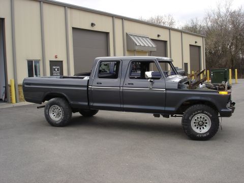 1979 Ford F-250 - This crew cab pickup truck is parked in front of a commercial building with large garage doors.