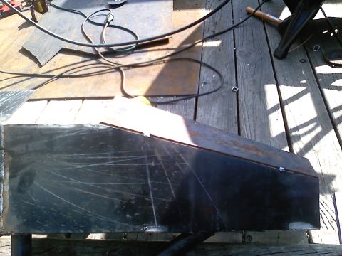 1990 Ford Bronco - A metal part is shown on a wooden deck, with tools and wires nearby.
