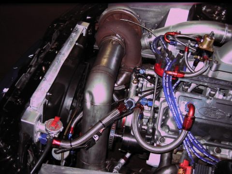 1992 Ford Mustang - Close-up of a modified engine a turbocharger and extensive custom plumbing.