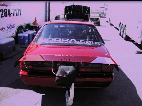 1992 Ford Mustang - This red drag car has a large spoiler and a drag chute attached to the rear bumper.