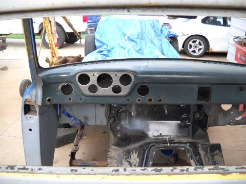 1954 Ford F-100 - The dashboard of a vintage truck is shown with its gauges removed, in a state of repair.