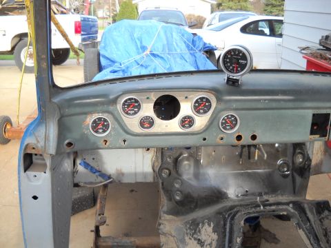 1954 Ford F-100 - The dashboard of a disassembled truck, several aftermarket gauges and a tachometer, is shown in an interior view.