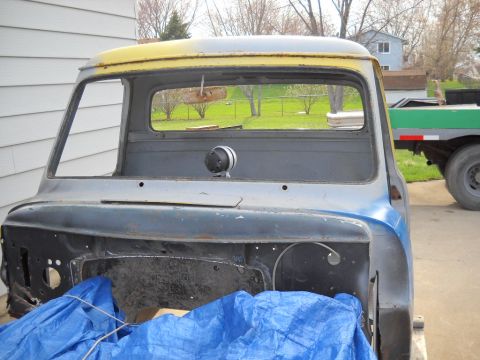 1954 Ford F-100 - Front view of a 1953 Ford F-100 truck cab undergoing restoration, with the engine bay exposed.