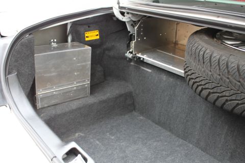 2003 Ford Crown Victoria - Trunk interior with a metal storage box and a spare tire visible.