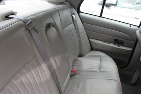 2003 Ford Crown Victoria - Interior view of the rear seats and door panel of a vehicle.