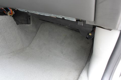 2003 Ford Crown Victoria - Exposed wiring is visible beneath the carpeted dashboard area of a car interior.