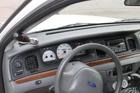 2003 Ford Crown Victoria - The interior of a car shows the dashboard with a steering wheel, radio, and instrument cluster.