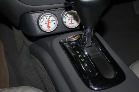 2003 Ford Crown Victoria - Close-up of a car's center console, displaying oil pressure and voltage gauges alongside the automatic transmission selector.