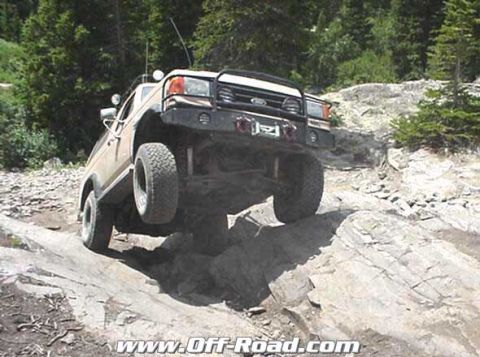 2002 Ford F-350 - A Ford Bronco navigates a challenging rocky terrain on an off-road trail.
