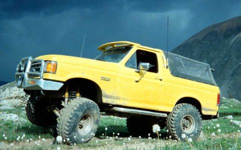 2002 Ford F-350 - This lifted Bronco features a brush guard and soft top, appearing to be from the late 1980s.