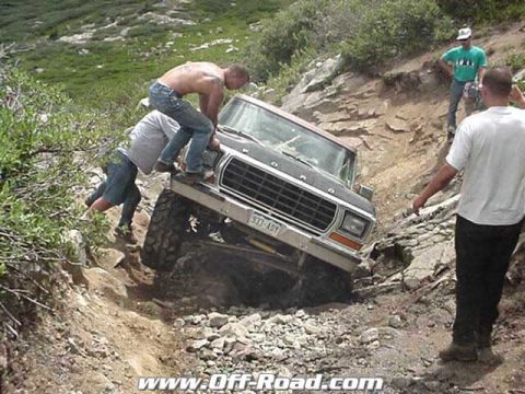 2002 Ford F-350 - Ford truck stuck on a rocky trail with people trying to push it free.