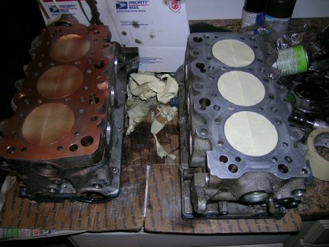 1995 Ford Probe - Engine cylinder heads are shown, one with a copper gasket and the other with taped openings.