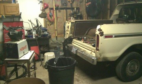 1978 Ford Bronco - The rear of a white 1978 Ford Bronco is visible, with its tailgate open and tools scattered within.